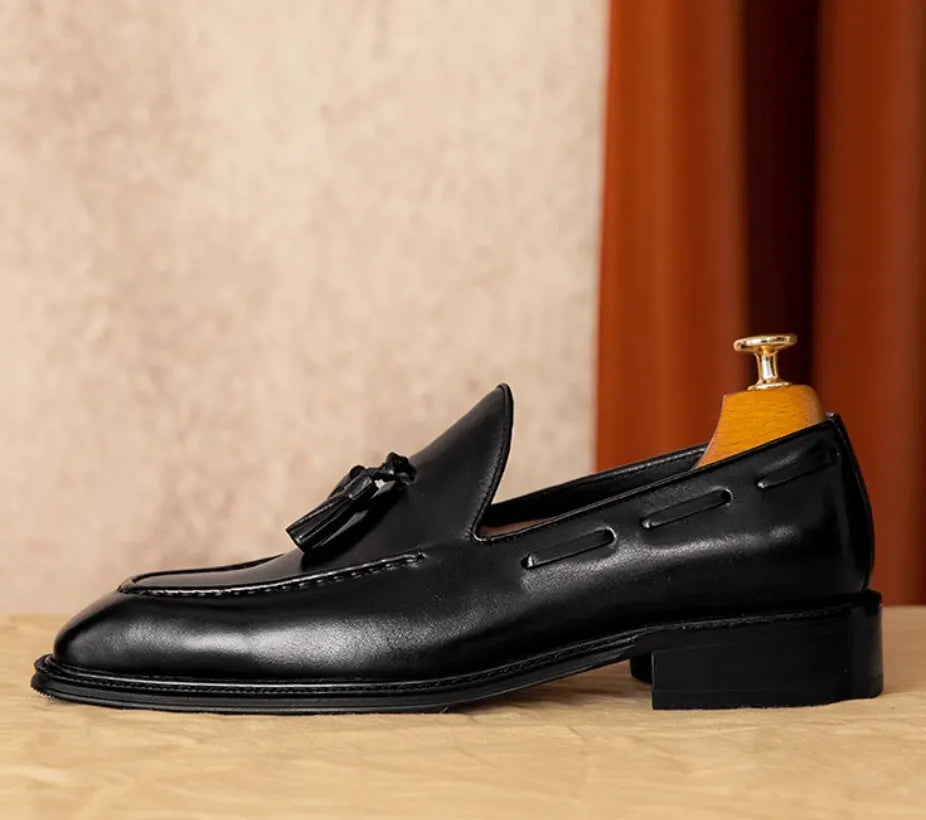 Men's black leather slip-on loafers with fringed detailing and polished finish