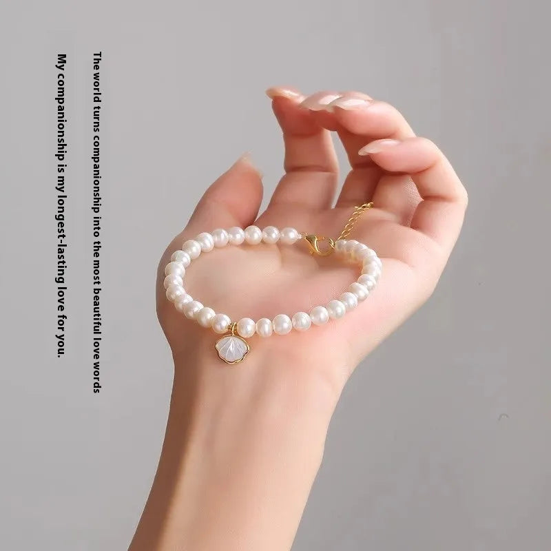 Close-up of a women's freshwater pearl bracelet with pearls arranged in a fan shape on a wrist.