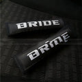 Pair of black car seatbelt shoulder pads showing embroidery detail and thickness