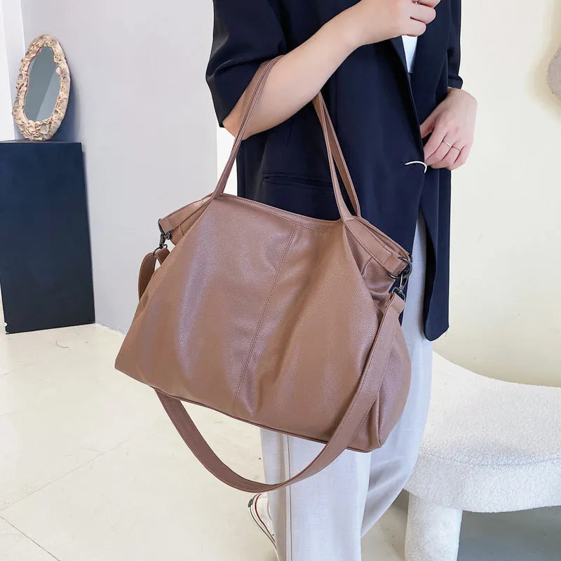 Large horizontal square soft-surface PU leather messenger bag with a long shoulder strap and zip opening.