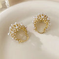 Gold tone copper flower basket earrings with small rice-shaped beads and a central pearl inlay.