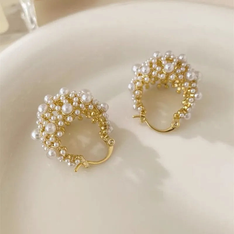 Gold tone copper flower basket earrings with small rice-shaped beads and a central pearl inlay.