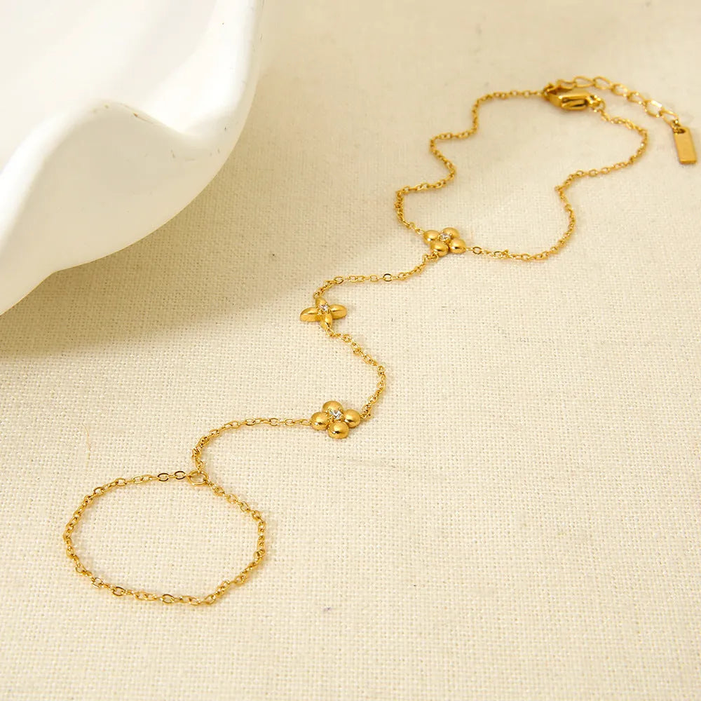 Gold colour women's bracelet with geometric eight-pointed stars and floral design elements on stainless steel