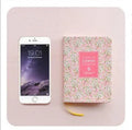 Green floral pattern notepad with fabric leather cover showing wireless binding and open pages