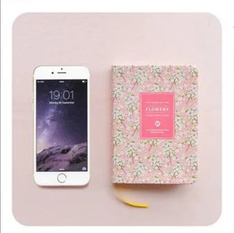Green floral pattern notepad with fabric leather cover showing wireless binding and open pages