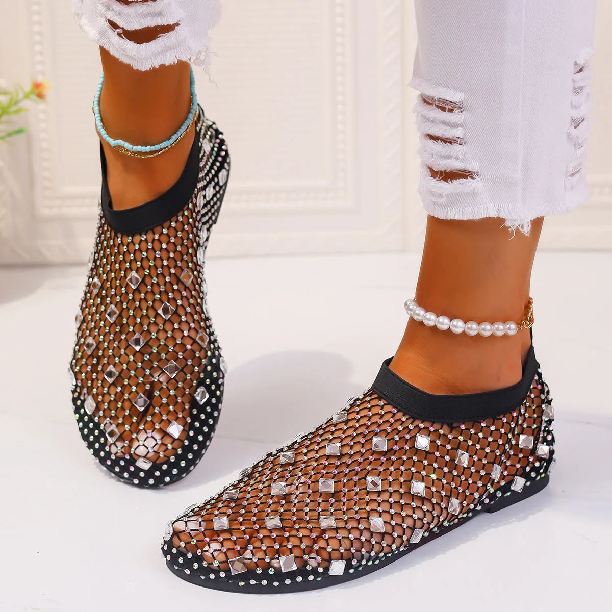 Women's flat mesh sandals with colourful rhinestone decoration on the upper and a round toe.