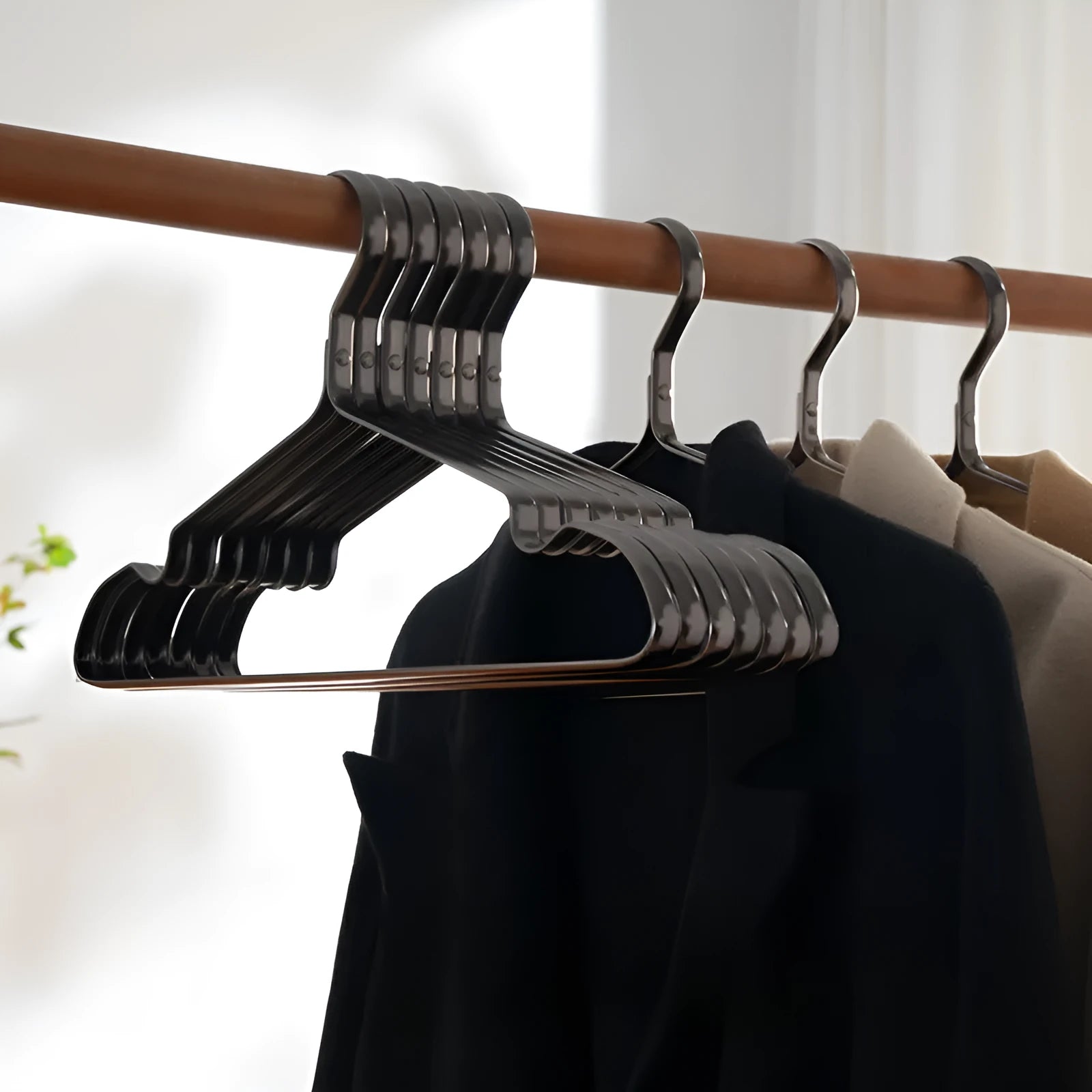Elegant black modern clothes hanger with non-slip shoulders on a white background.