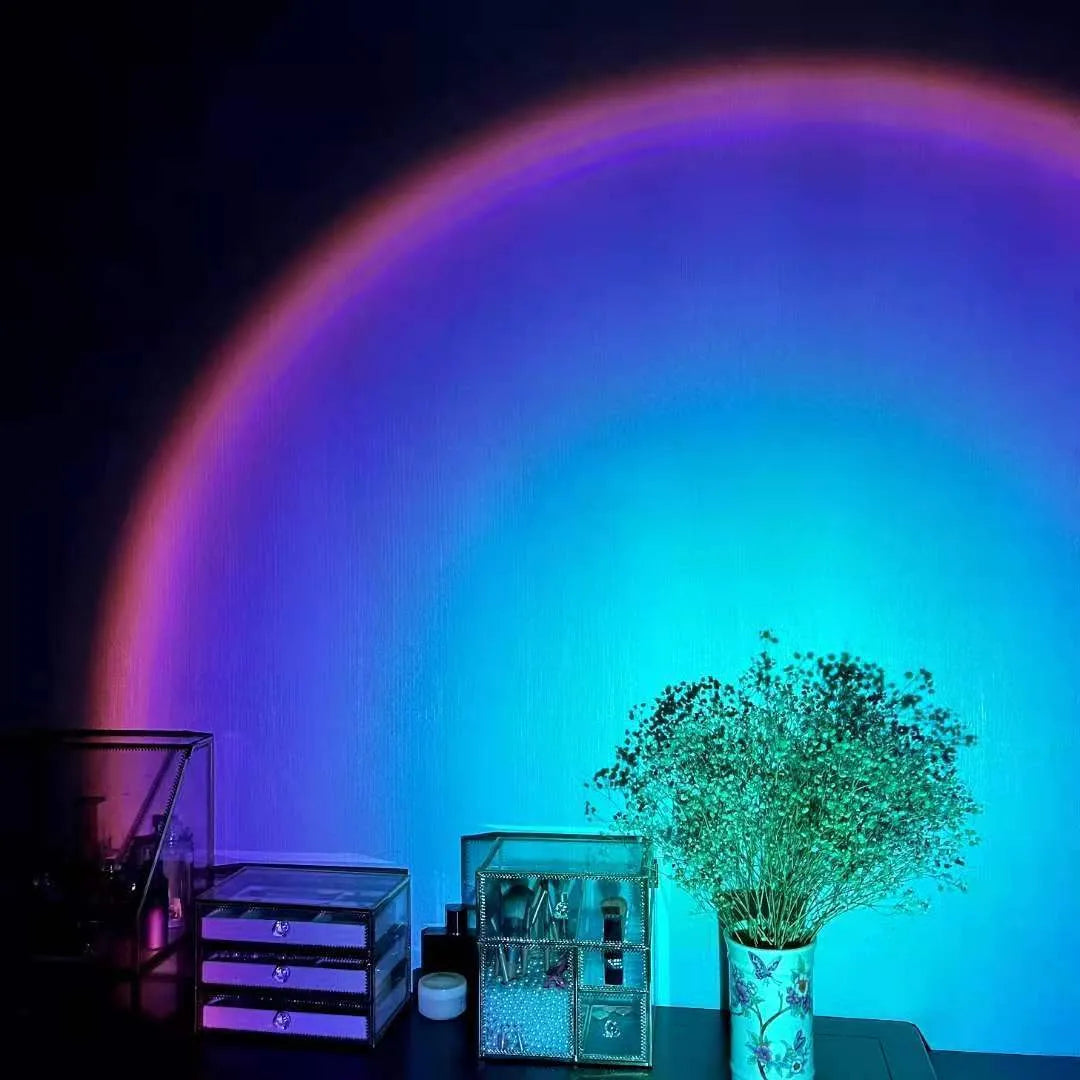Rechargeable sunset projection lamp showing rainbow colour patterns with USB power cable