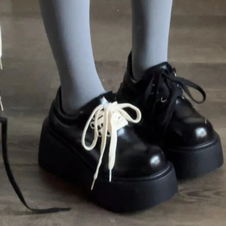Women's matte black lace-up heeled shoes with thick rubber sole and block heel on a plain background