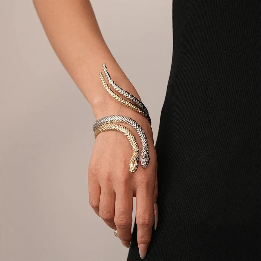 Gold tone snake-inspired bracelet and ring set with exaggerated twisted winding design on white background