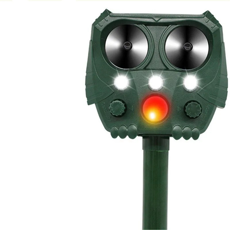 Green solar ultrasonic animal repeller unit with LED strobe lights for outdoor pest control.