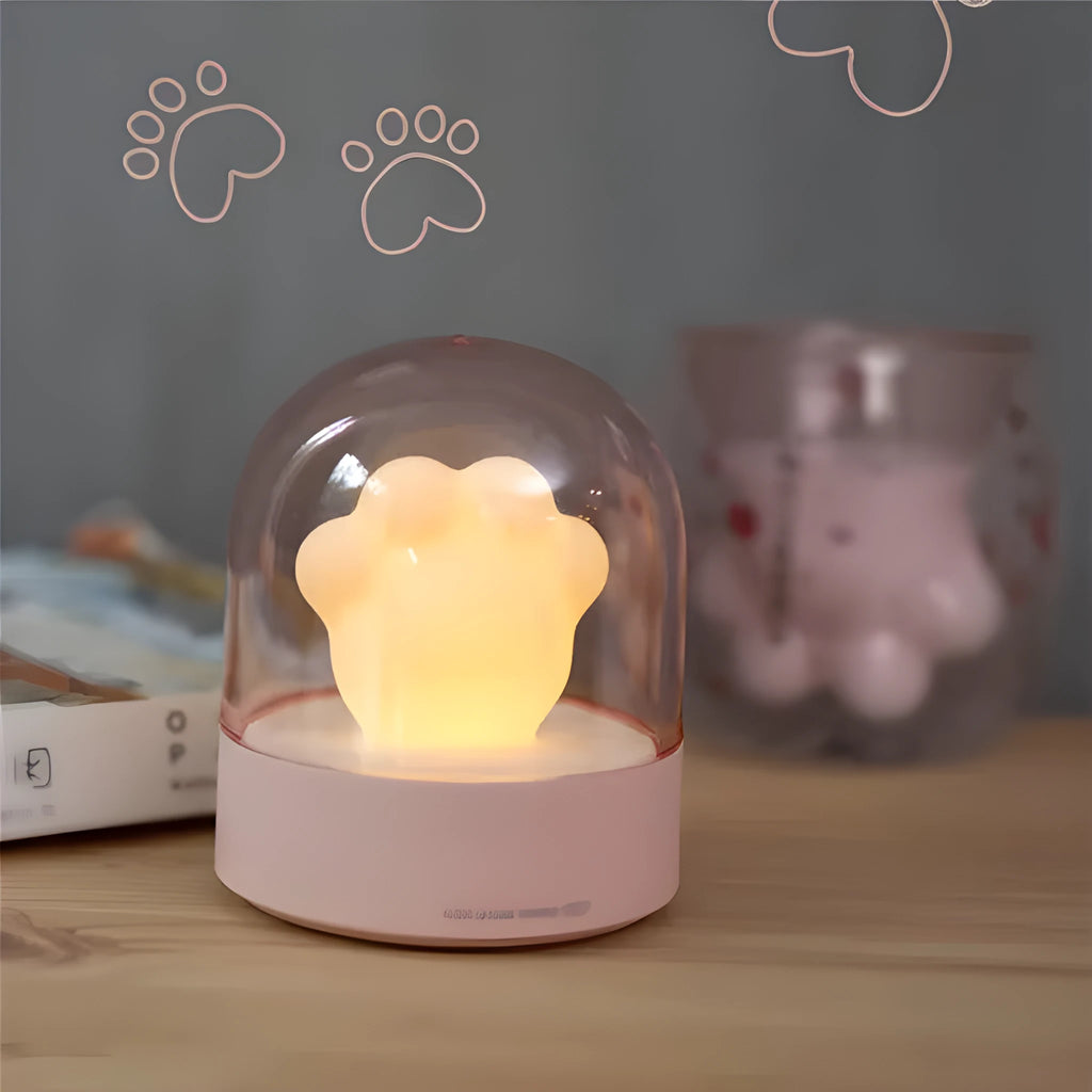 Grey cat paw shaped USB rechargeable night light with music box on a desk.