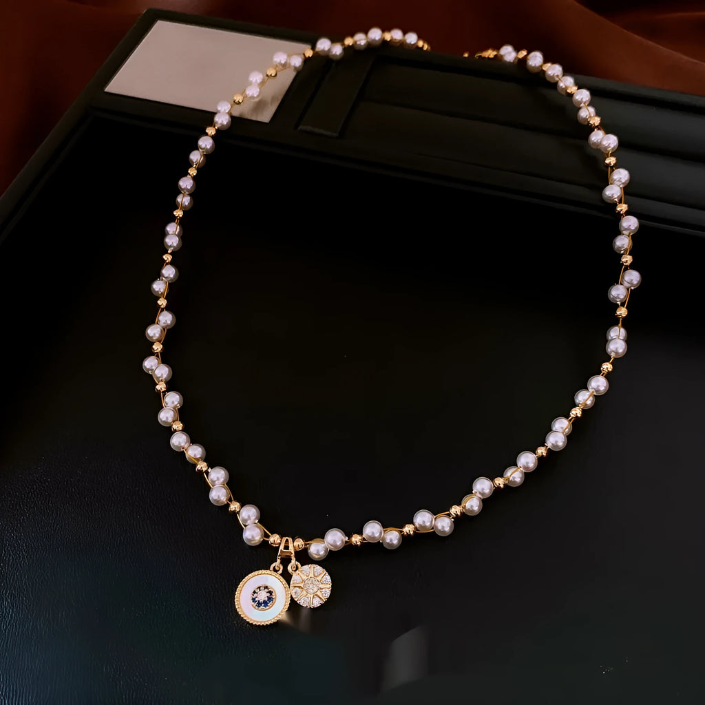 Gold electroplated necklace with round imitation pearl pendant and zircon detailing on adjustable clavicle chain