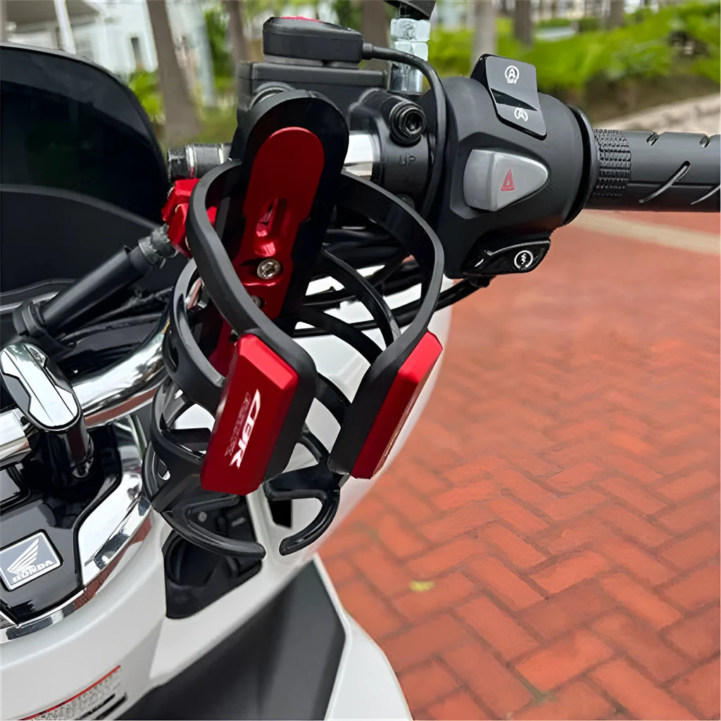 Modified black water bottle cage for Honda X-ADV scooter on handlebars.