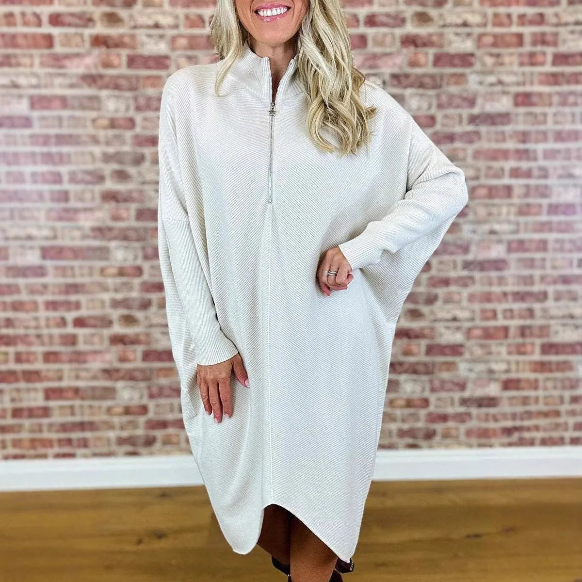 Women's solid colour loose knitted dress with raglan sleeves and a front zip closure.