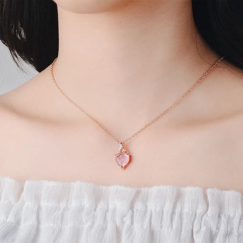 Women's necklace with heart-shaped pink crystal pendant on rose gold cross chain
