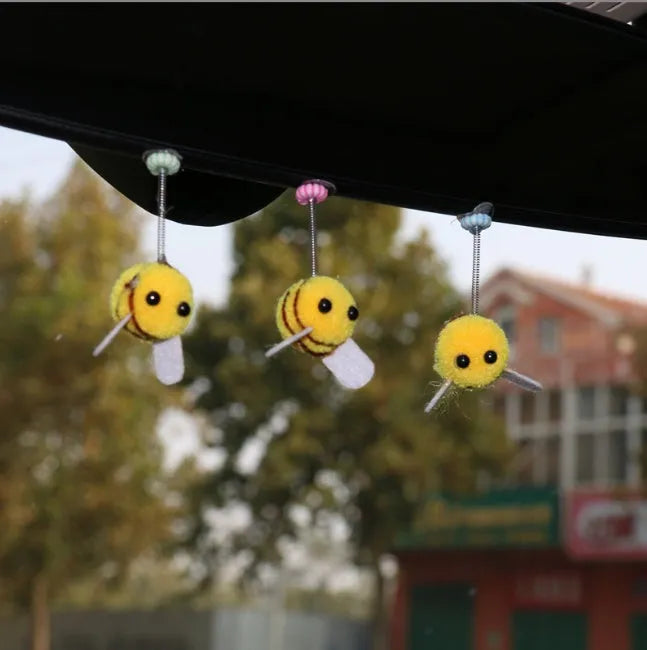 Small yellow and black fur ball bee car ornament with adhesive backing.