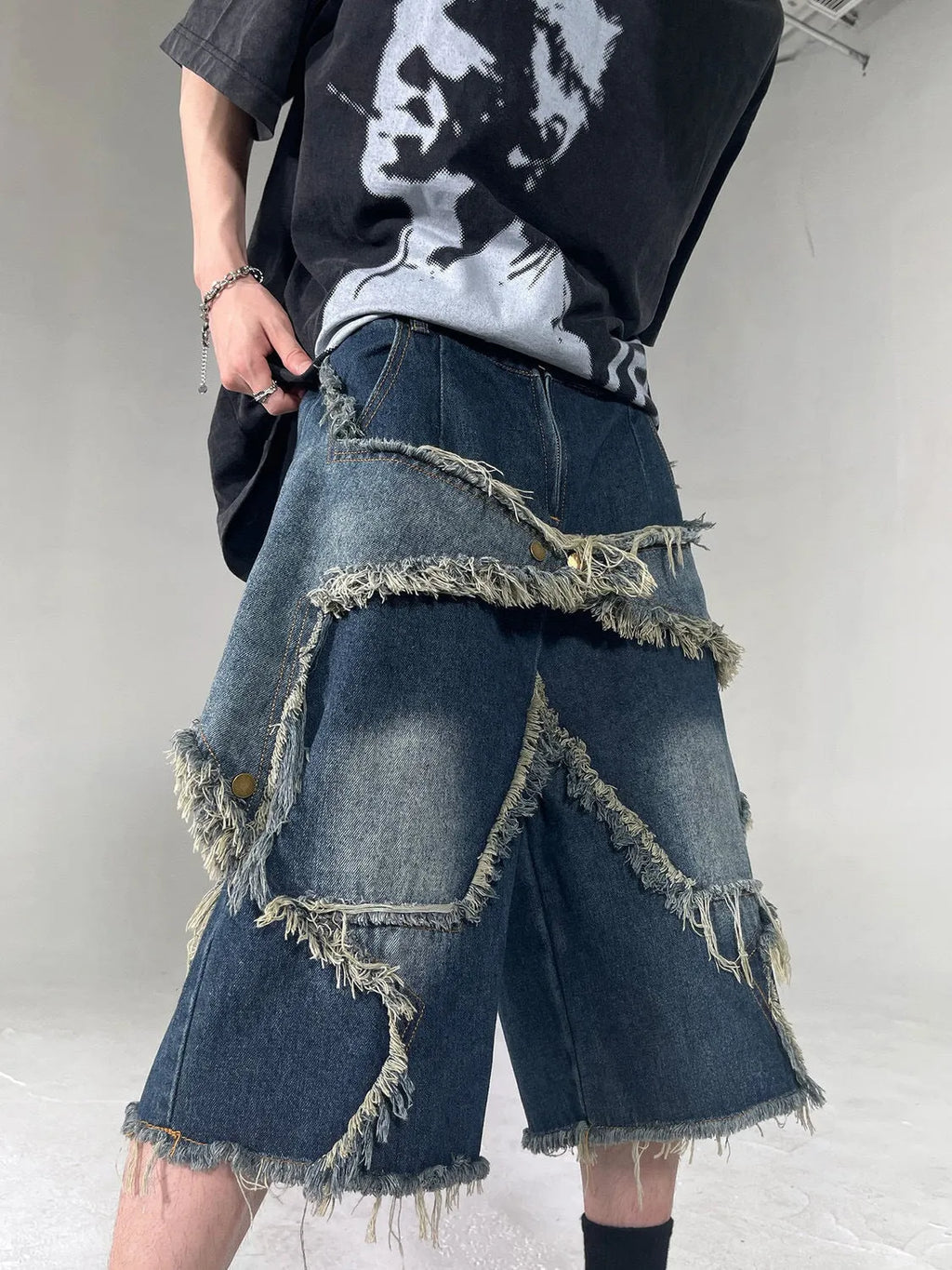 Blue denim shorts with frayed hems and star patches in loose fit American retro style