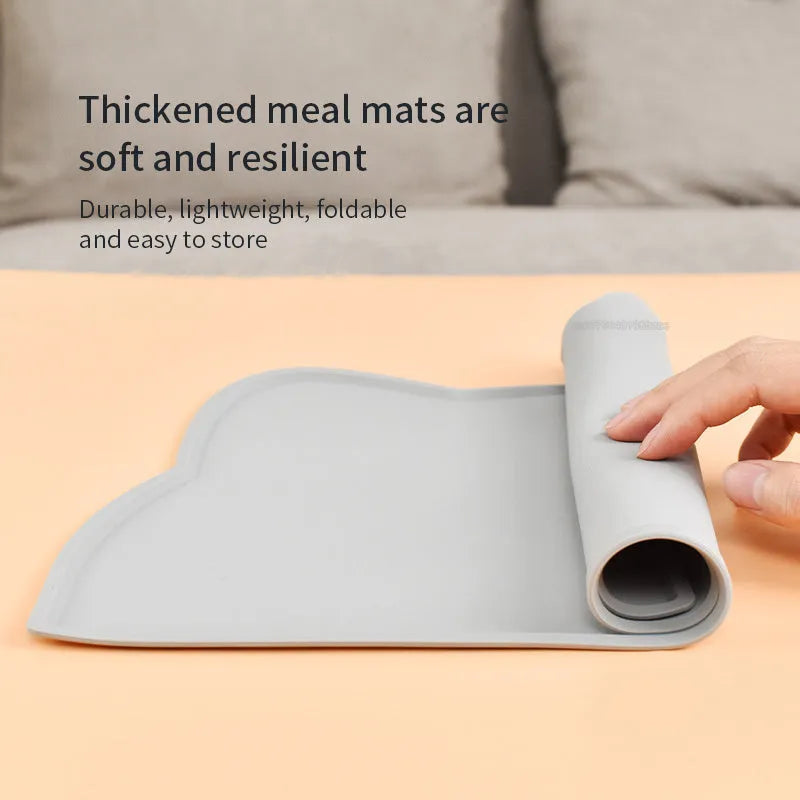 Blue silicone pet feeding mat for dog or cat bowls on a wooden floor.