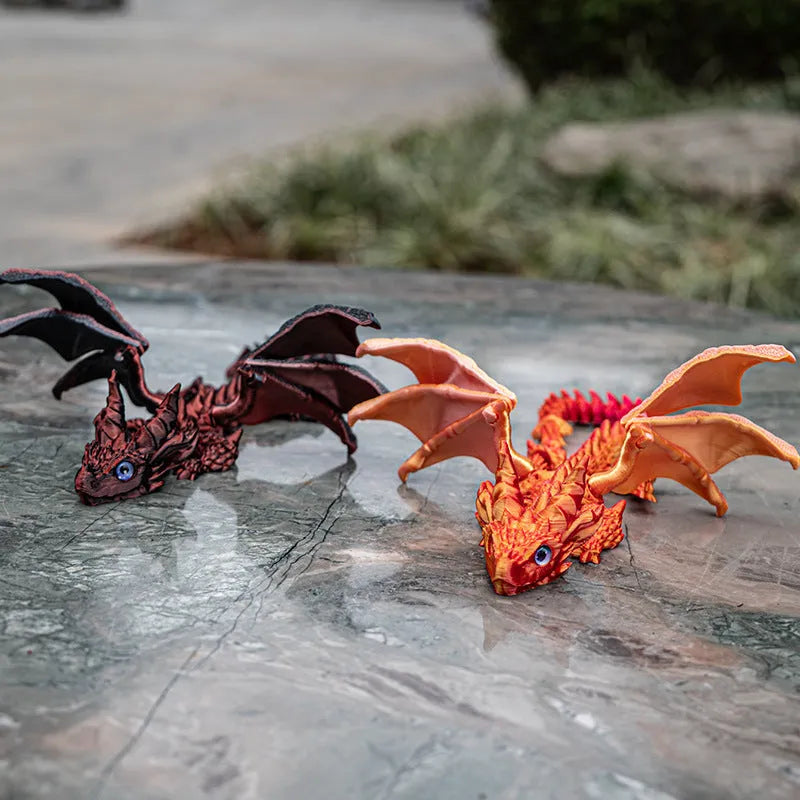 3D printed red and gold flying dragon wings decoration toy on a white background.