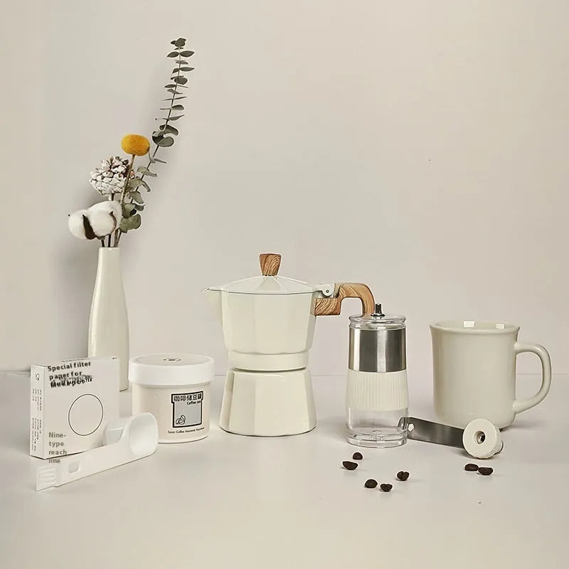 Six-piece manual grinding machine set in beige and black with moka pot, cup, bean jar, and accessories