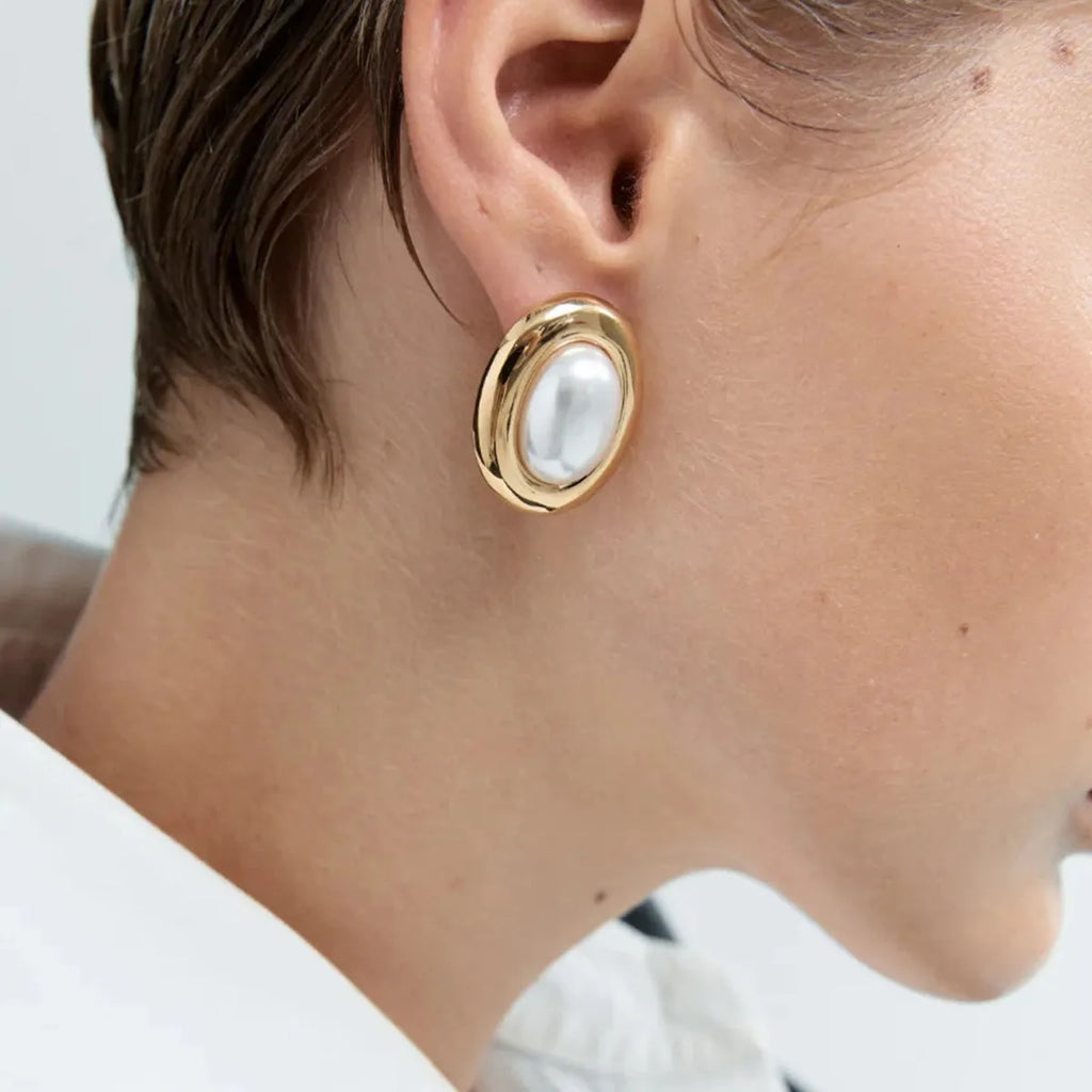 A pair of stainless steel stud earrings with a vintage-style faux pearl centre in colour JDE0305051.