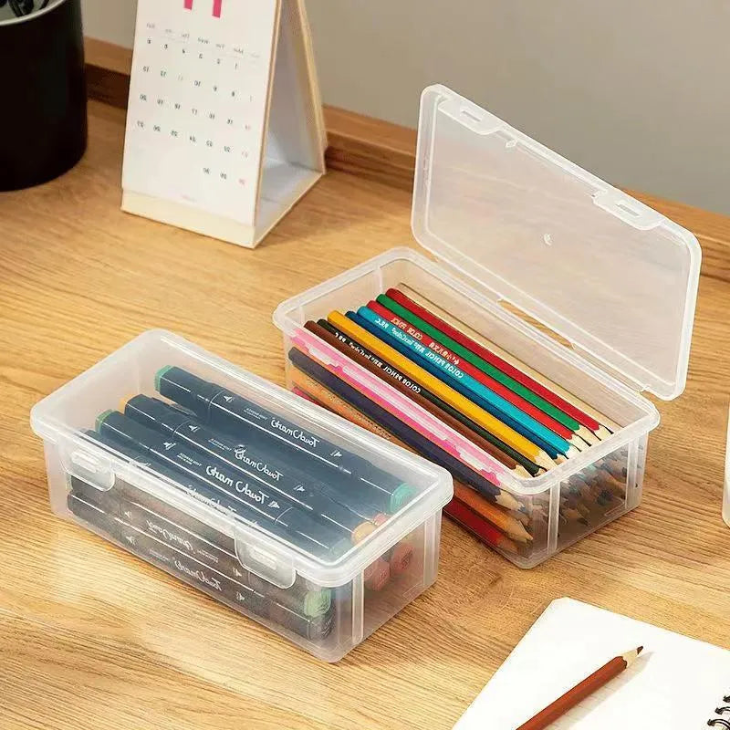 Clear plastic storage box for pencils, colouring leads, and children's crayons on a desk.