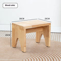 Solid wooden shoe changing stool with a distressed finish, shown in a living room setting.