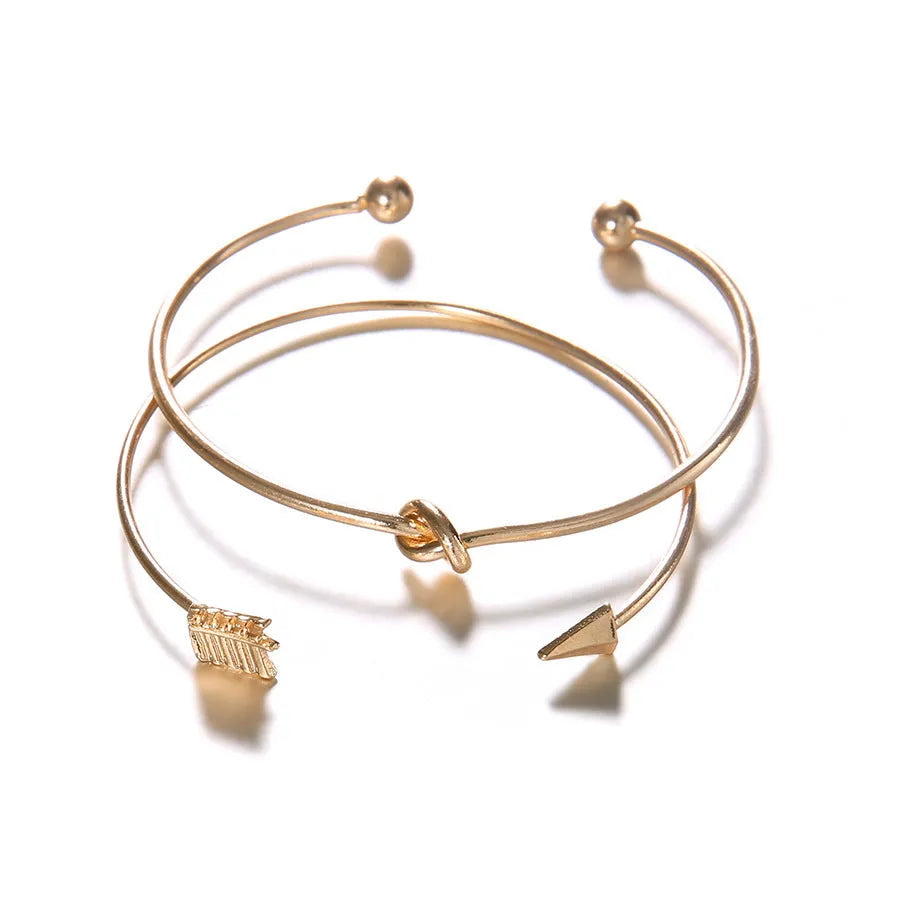 Gold Maili women's vintage cuff bracelet with arrow knot design.