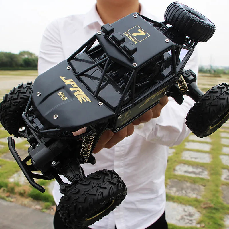 Black and silver 4WD remote control off-road climbing cars on rough terrain showing two size options.