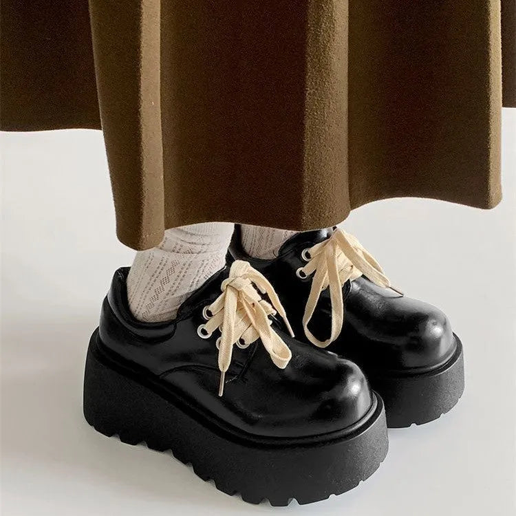 Women's matte black lace-up heeled shoes with thick rubber sole and block heel on a plain background
