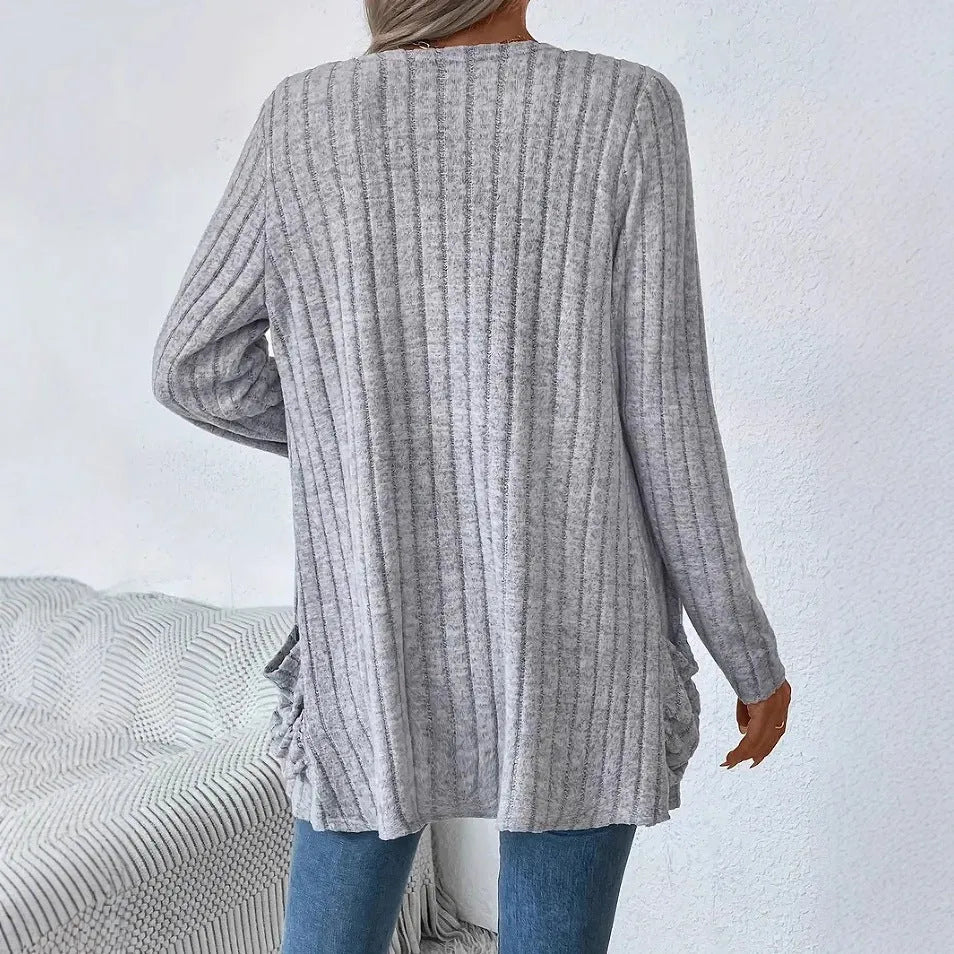 A person wearing a solid grey loose fit long sleeve cardigan with a chest pocket.