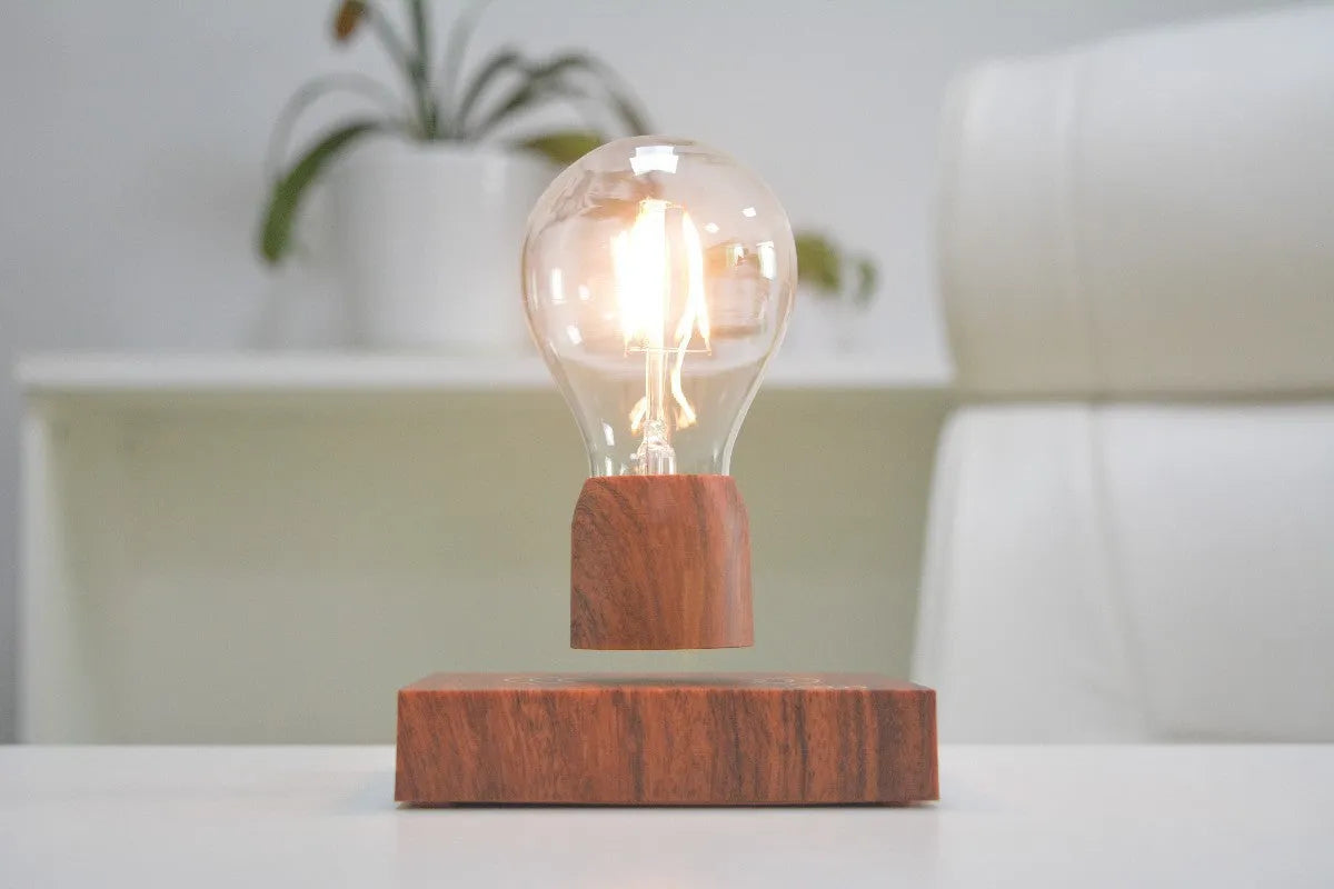 Magnetic levitation floating light bulb with imitation wood base on a table.
