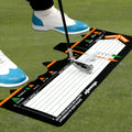 Black neoprene golf swing training mat with white alignment markings for stance correction.