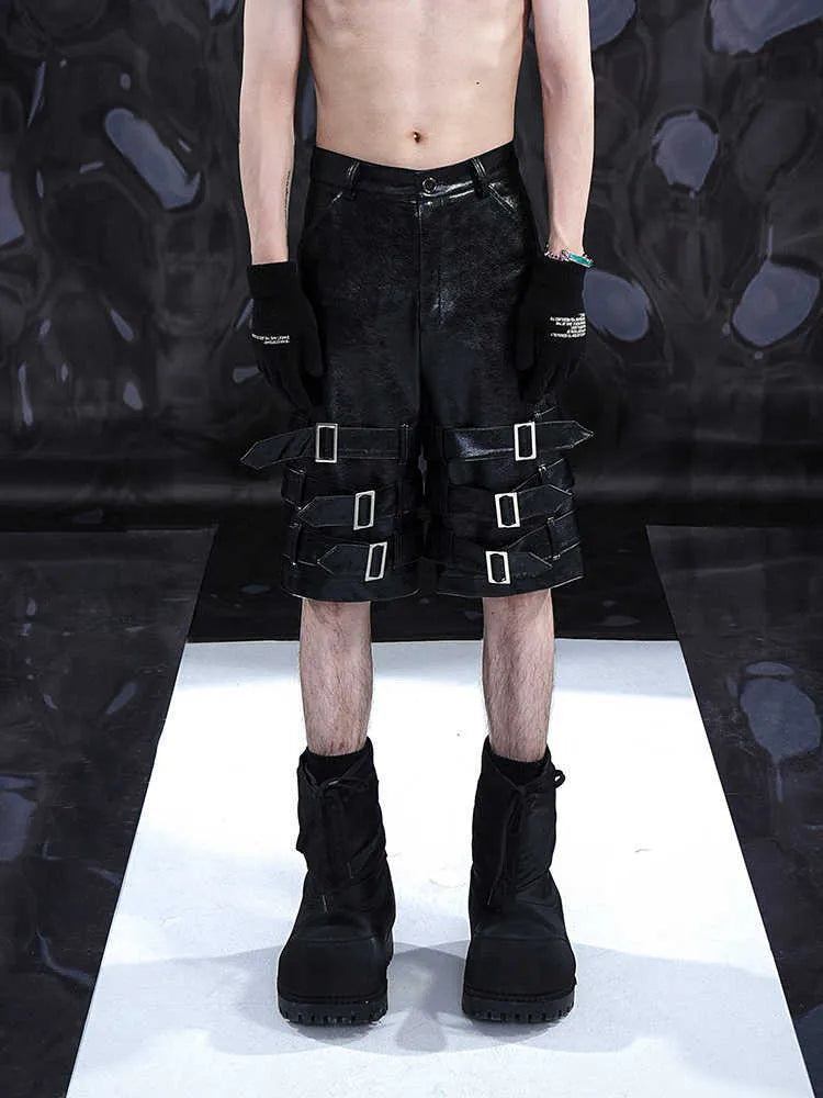 Black men's PU leather cropped shorts with a ring detail on the leg, shown on a model.