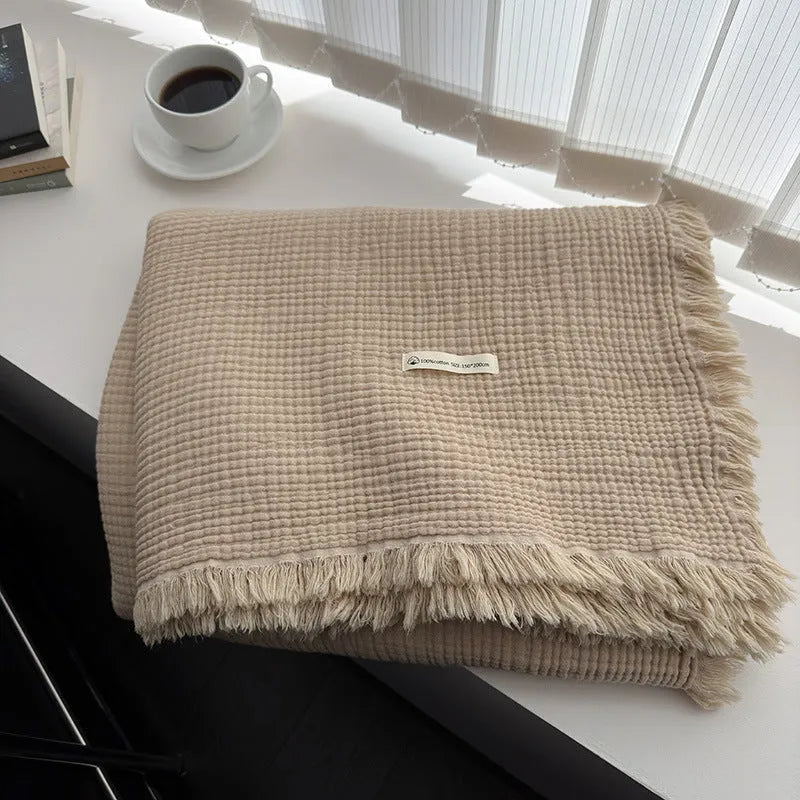 Four-layer gauze cotton blanket with tassel trim in a choice of ten colours and two sizes.