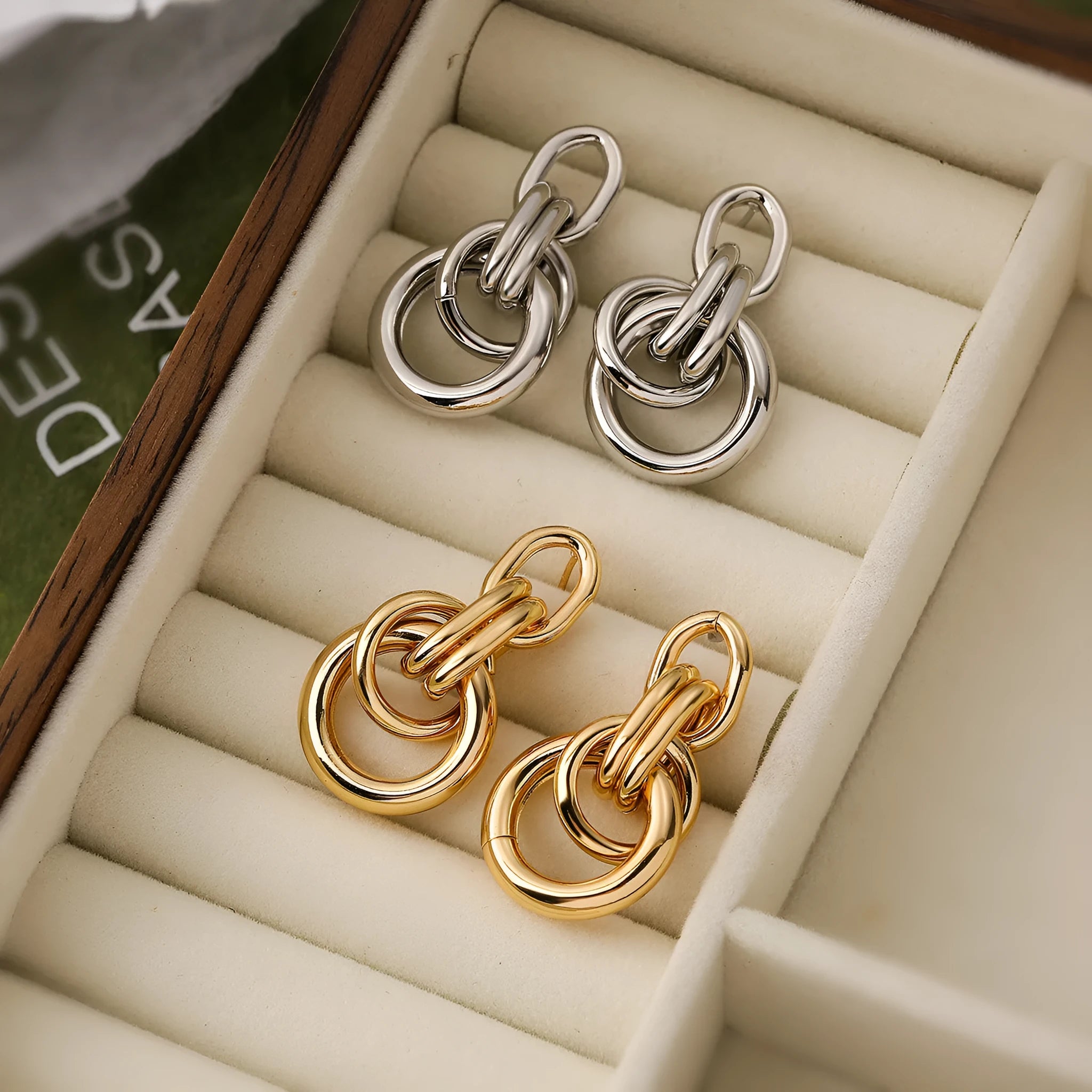 Geometric gold drop earrings with an irregular shape on a copper base.