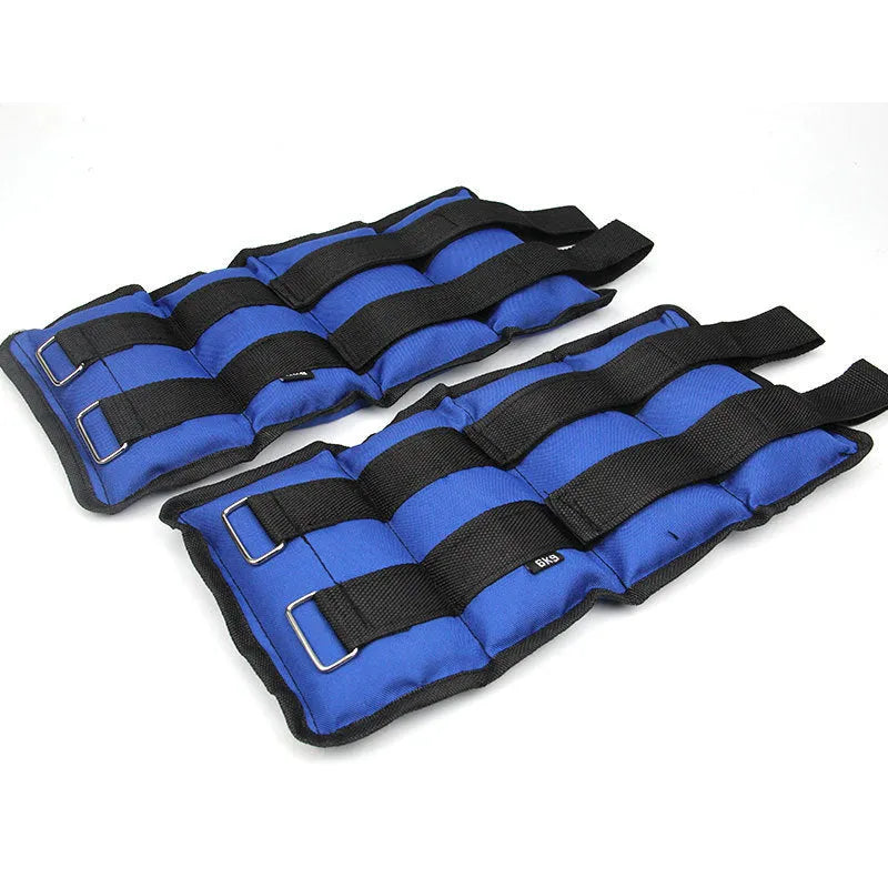A pair of black Oxford cloth legging sandbags with straps, shown with weight options from 1kg to 6kg for athletic training.