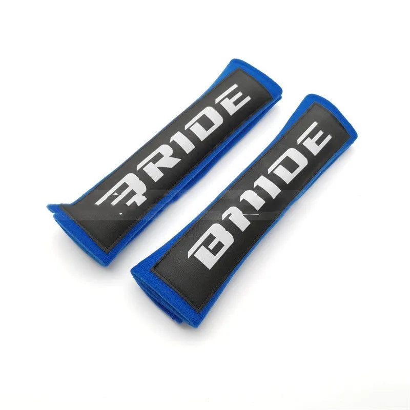 Pair of black car seatbelt shoulder pads showing embroidery detail and thickness