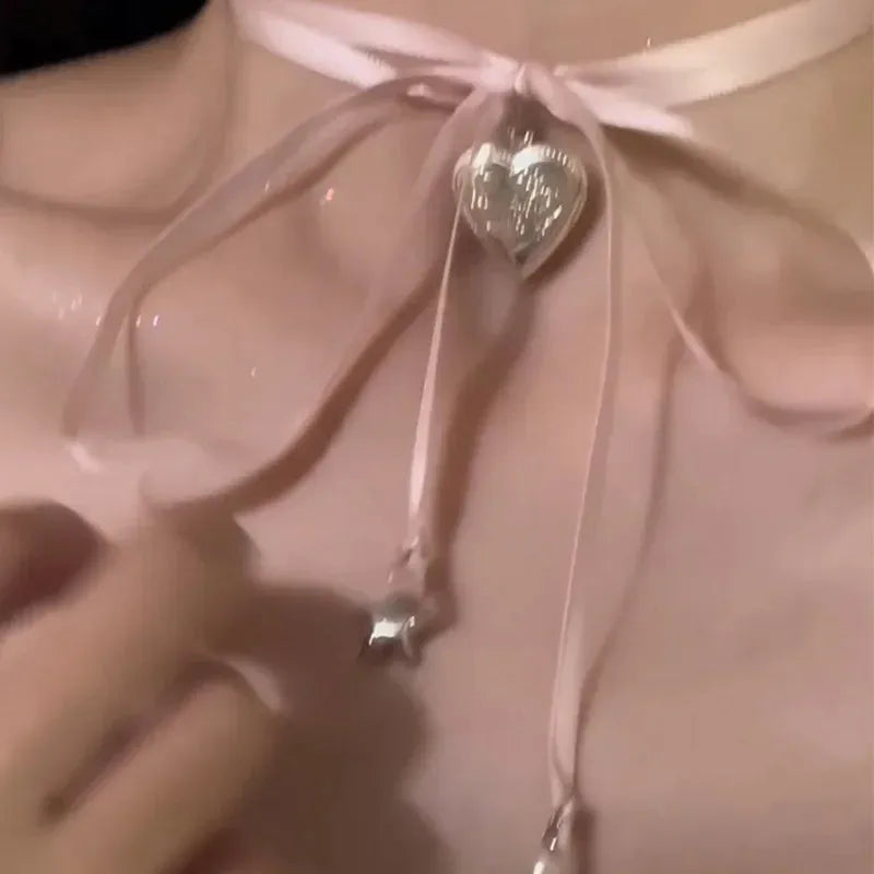 Women's ribbon love pendant fashion necklace on a clavicle chain, showing the alloy electroplated finish.
