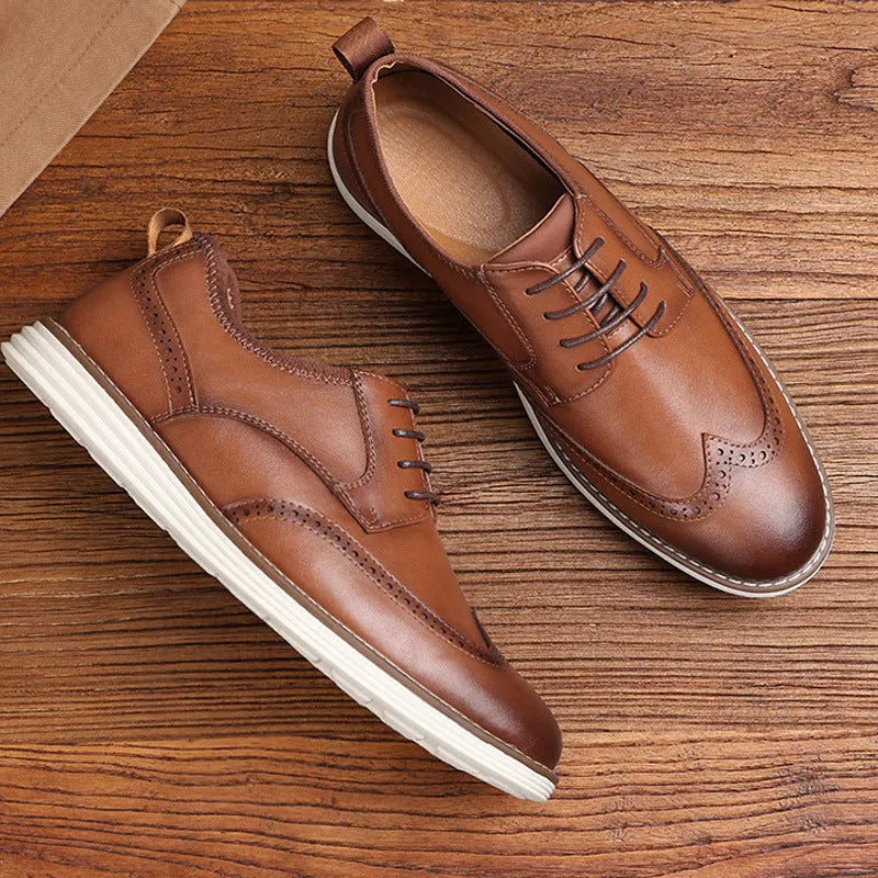 Men's black and brown slip-on casual shoes with round toe and carved detail on the upper.