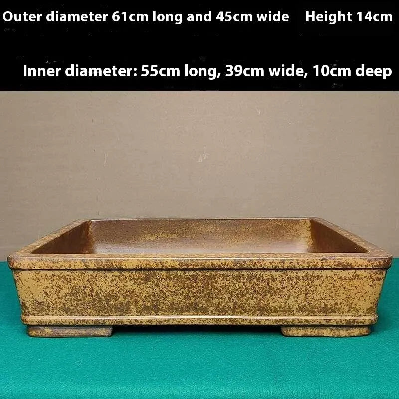 Straight shallow rectangular Yixing Zisha flowerpot in purple sand clay on a plain surface.