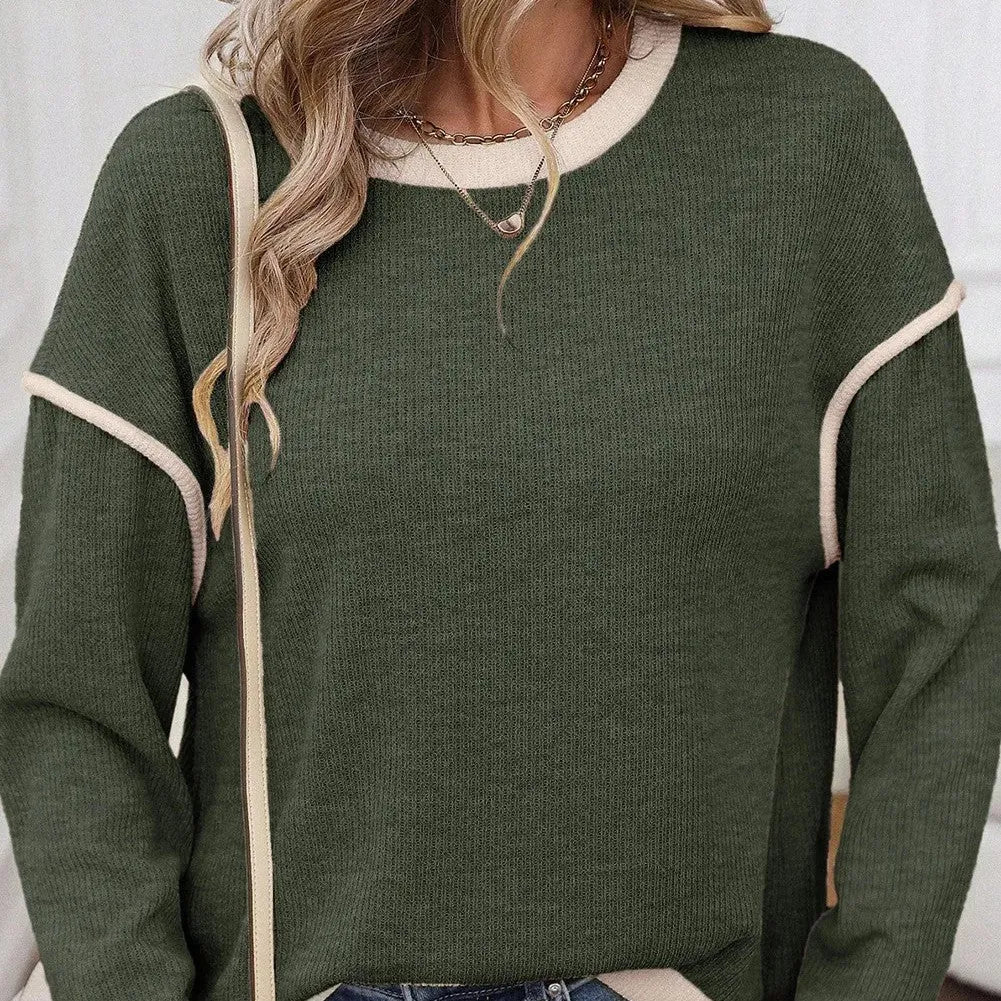 Women's beige loose knit top with green four leaf clover contrast trim on the V-neck and long sleeves.