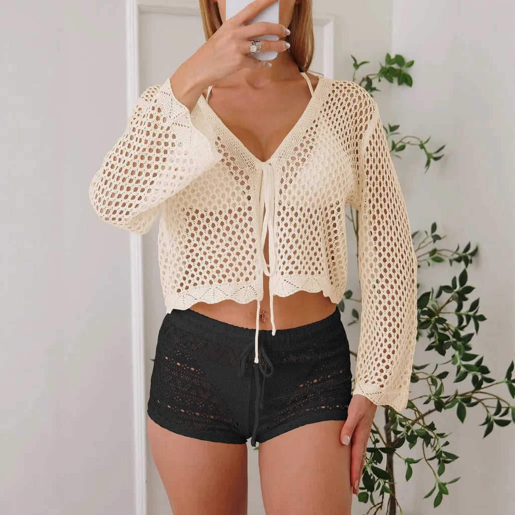 Women's apricot hollow knit cardigan blouse with bell sleeves laid flat.