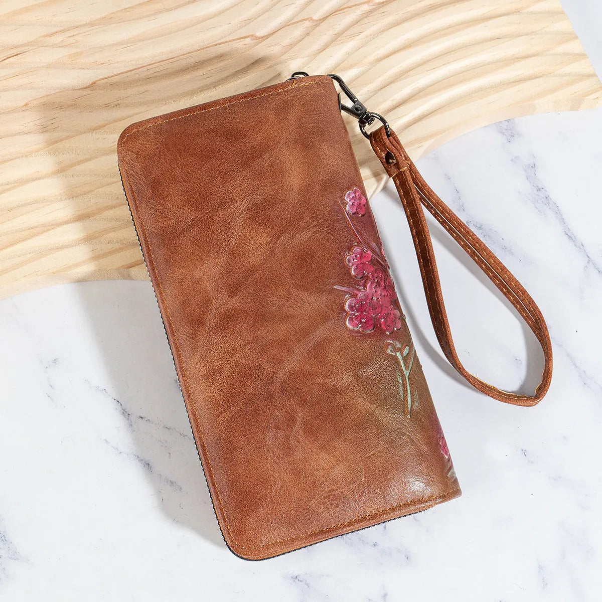 Embossed floral handbag with hand-painted details and a brass zipper in a retro style.