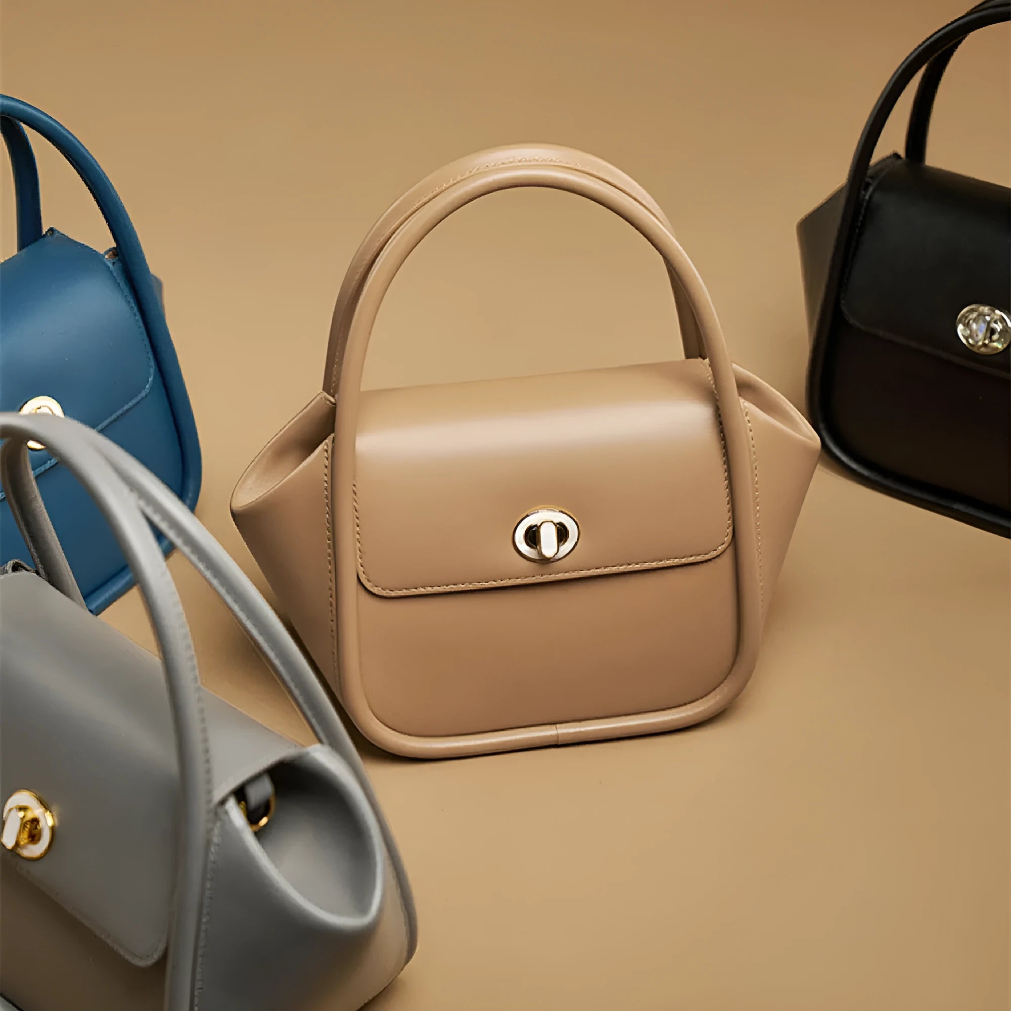 Brown leather wing-shaped tote bag with a buckle detail and latch closure, shown with a single cross-body strap.