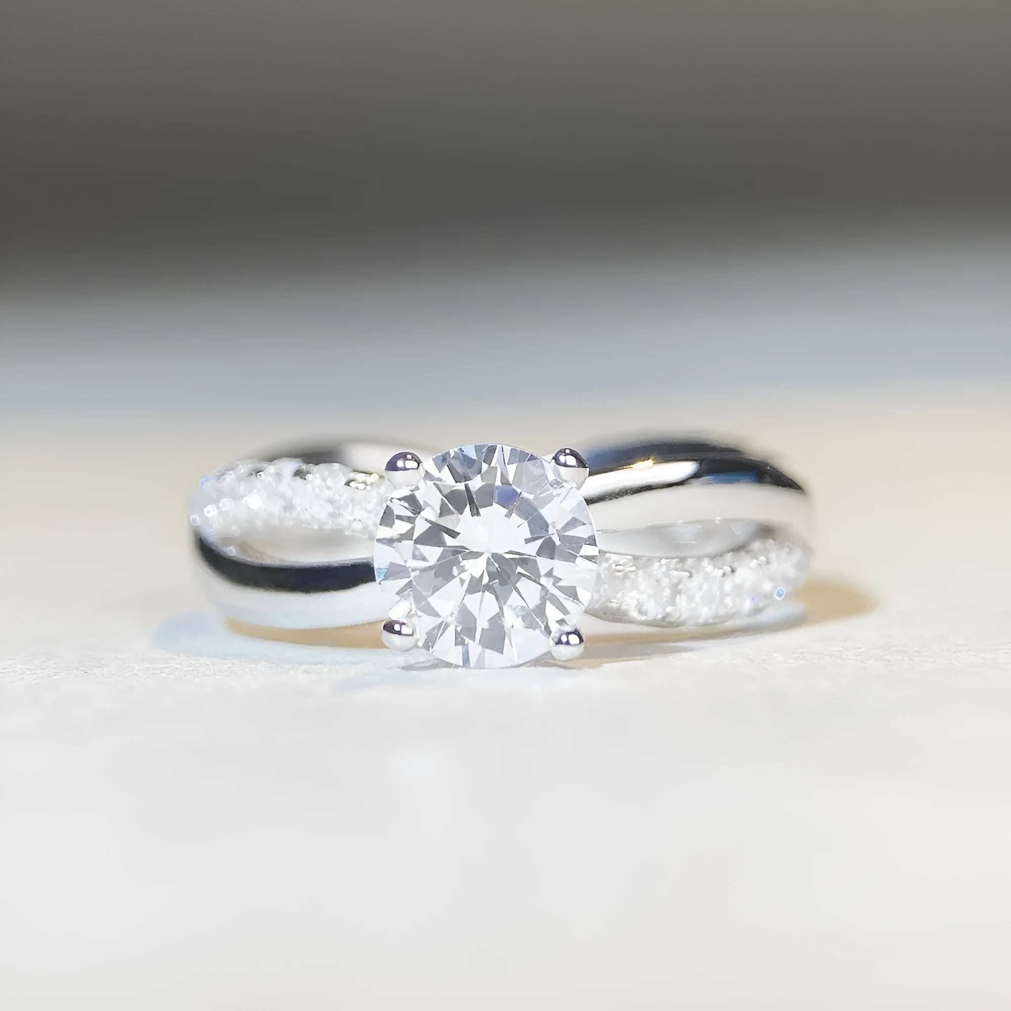 Silver ring with a 1 karat moissanite stone in a four-claw setting and a geometric twisted arm band.