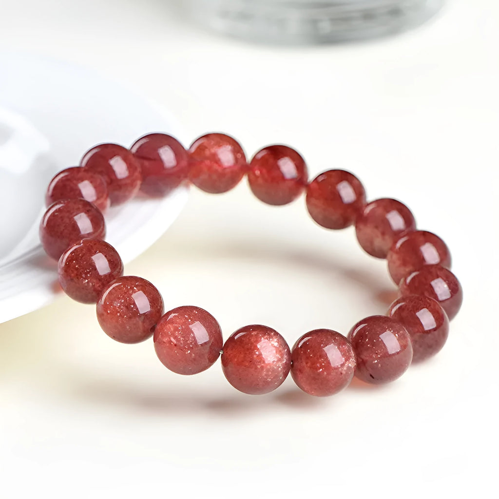 Natural cherry red strawberry quartz bracelet with geometry-shaped beads on a wrist.