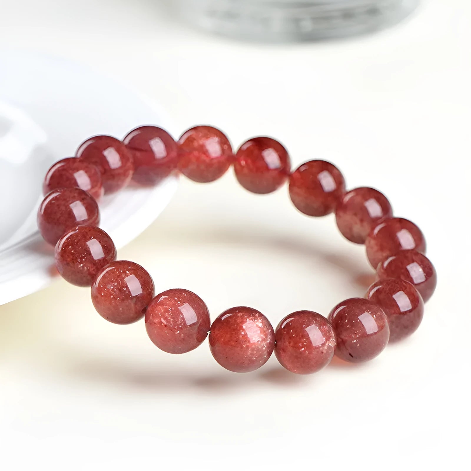 Natural cherry red strawberry quartz bracelet with geometry-shaped beads on a wrist.