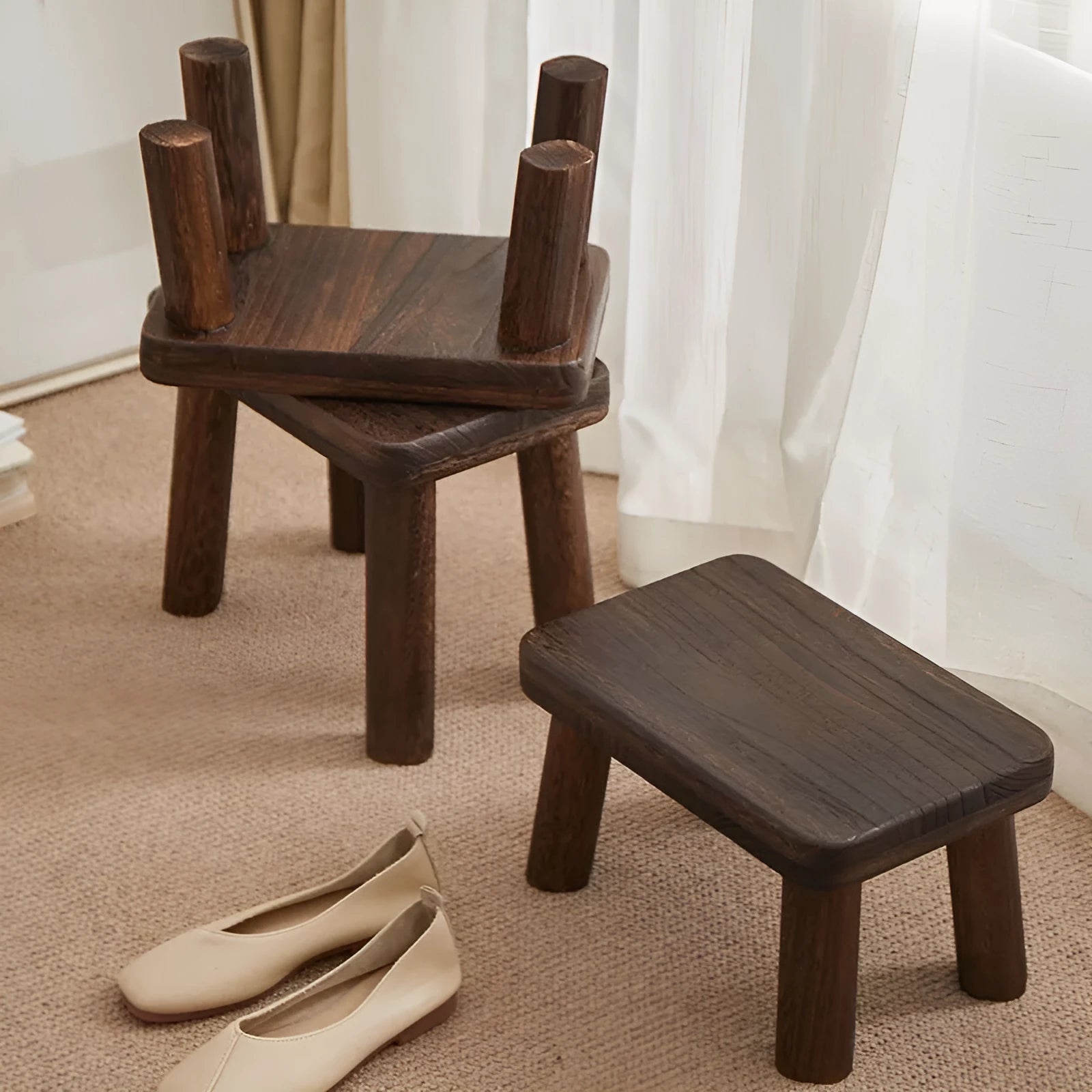 Solid wooden shoe changing stool with a distressed finish, shown in a living room setting.